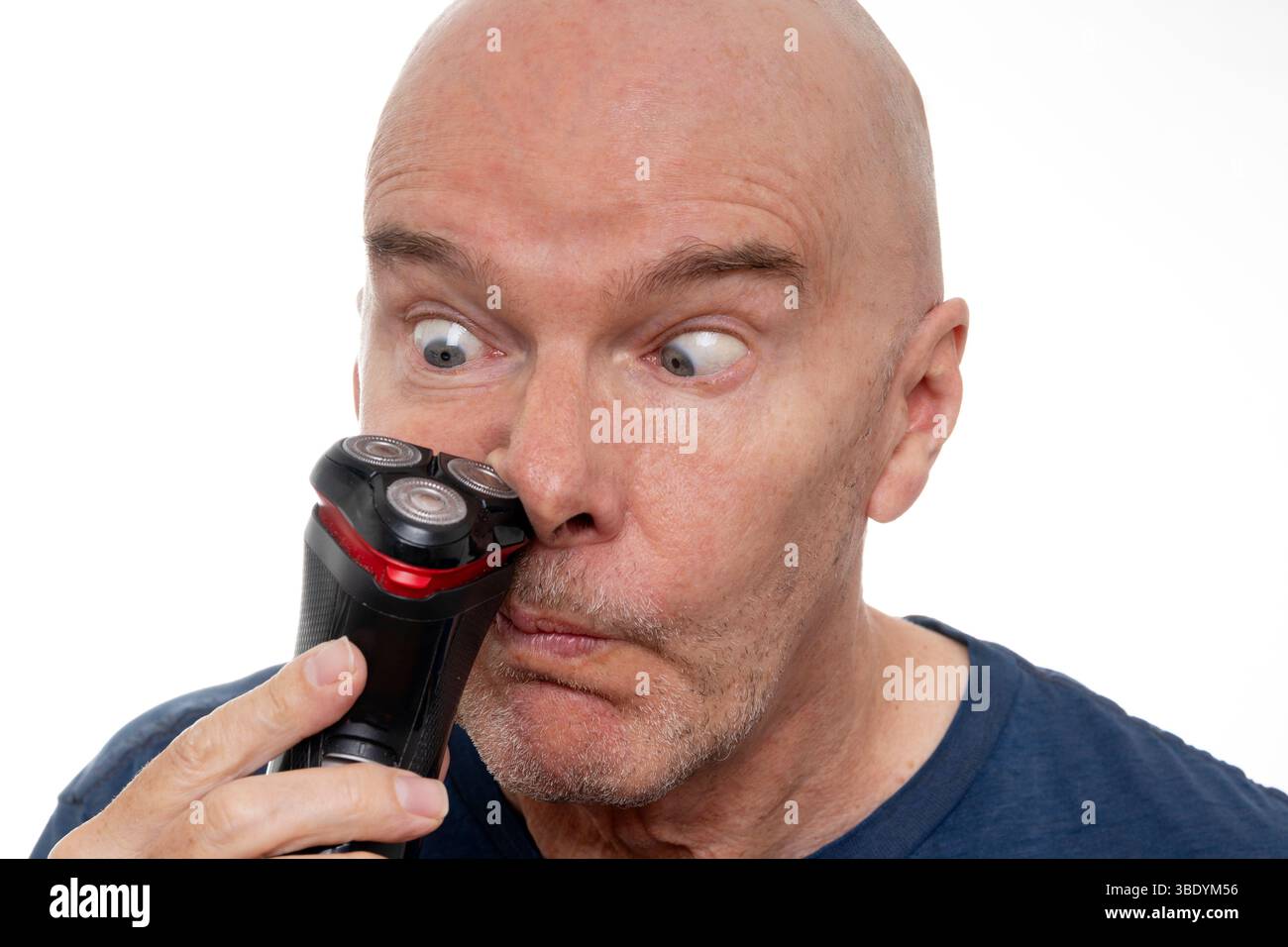 Uomo divertente che usa il rasoio elettrico per tagliare i peli del naso Foto Stock