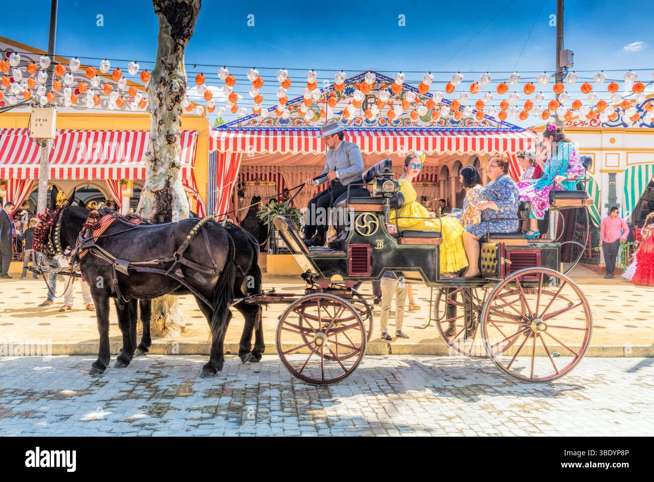 Siviglia, Spagna, 3 maggio 2017, le famiglie si deliziano con un tradizionale giro in carrozza trainata da cavalli attraverso la vivace Fiera di aprile di Siviglia, circondata da festi Foto Stock