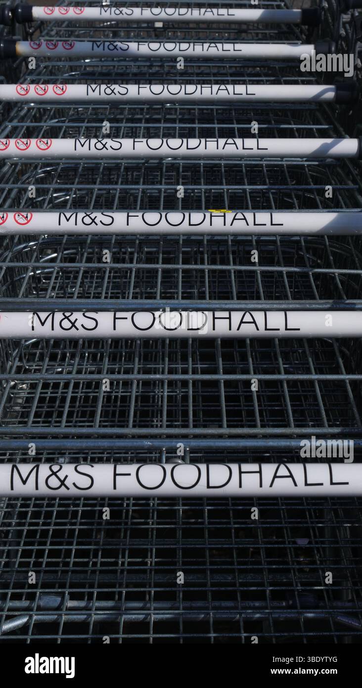 Il logo M&S Foodhall sui carrelli e sul negozio a Eastleigh, Regno Unito. Foto Stock