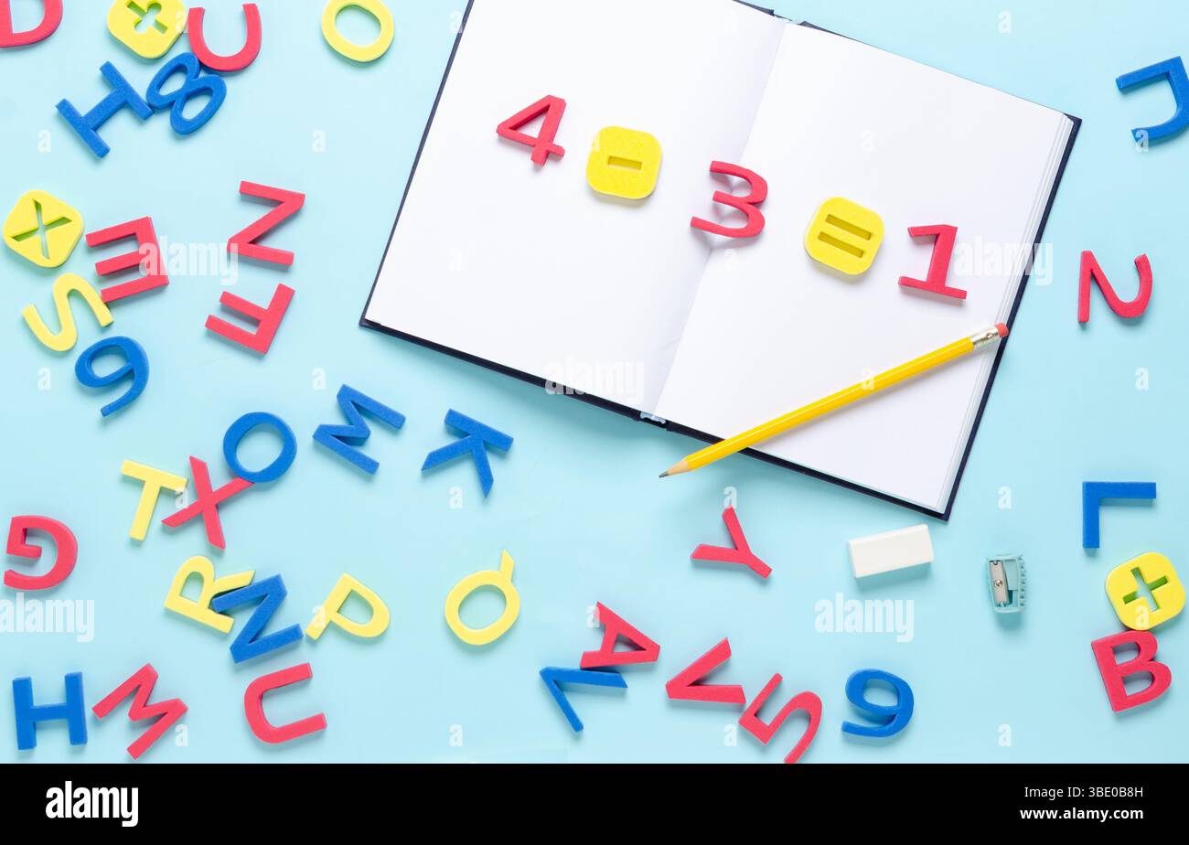 Equazione matematica con numeri e simboli sul notebook con lettere alfabetiche colorate sparse su sfondo azzurro. Ritorno al concetto di scuola. Foto Stock