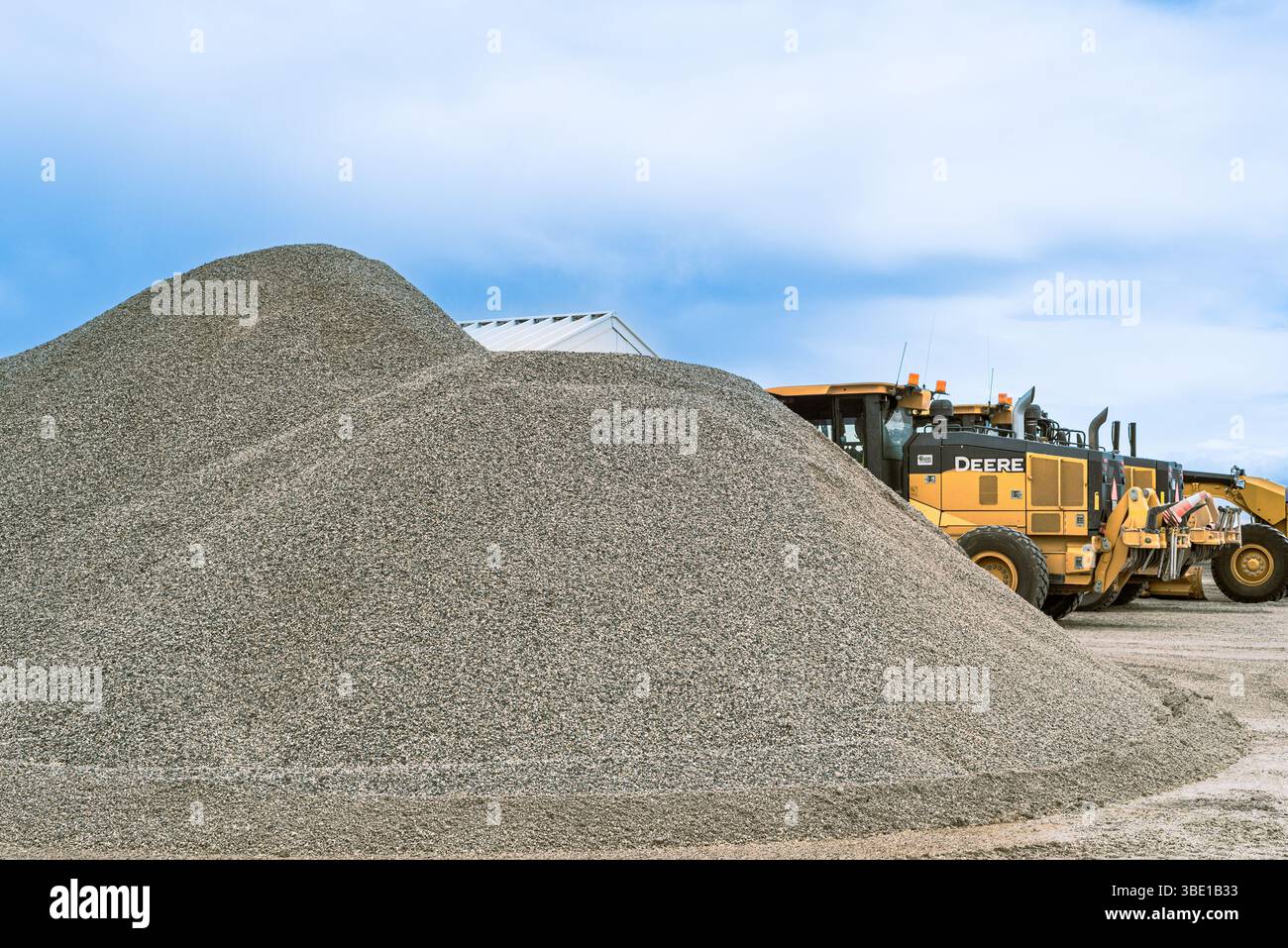 Alto mucchio di ghiaia e macchine John Deere, Colorado, Stati Uniti. Foto Stock