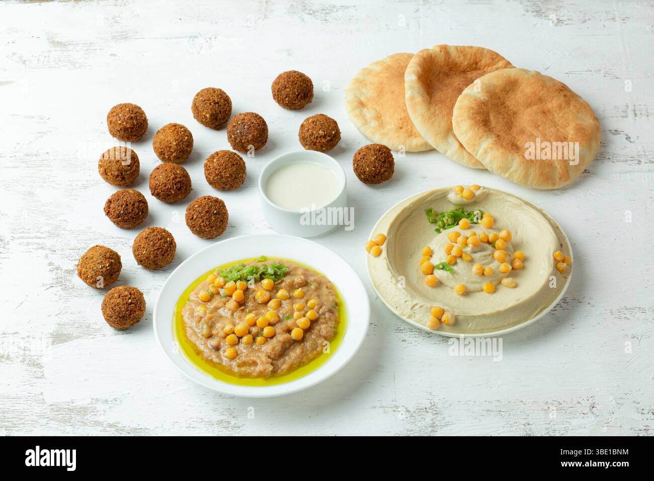 Colazione mediorientale con hummus, foul e falafel, servita con tahini cremosi Foto Stock