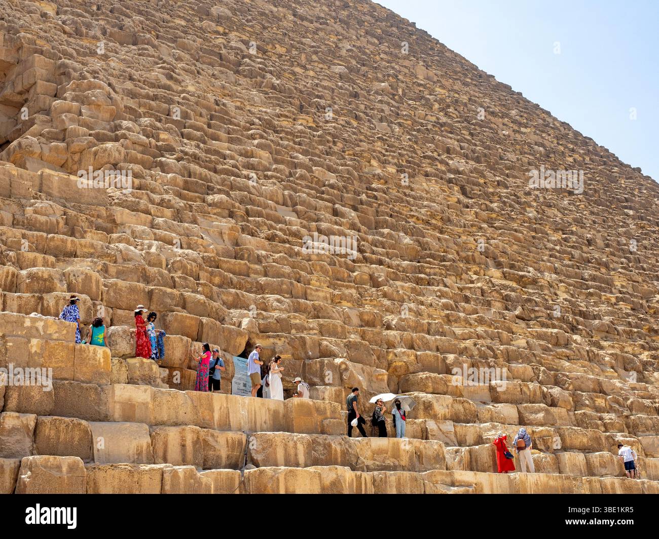 I visitatori che si arrampicano sulla grande Piramide di Giza Foto Stock
