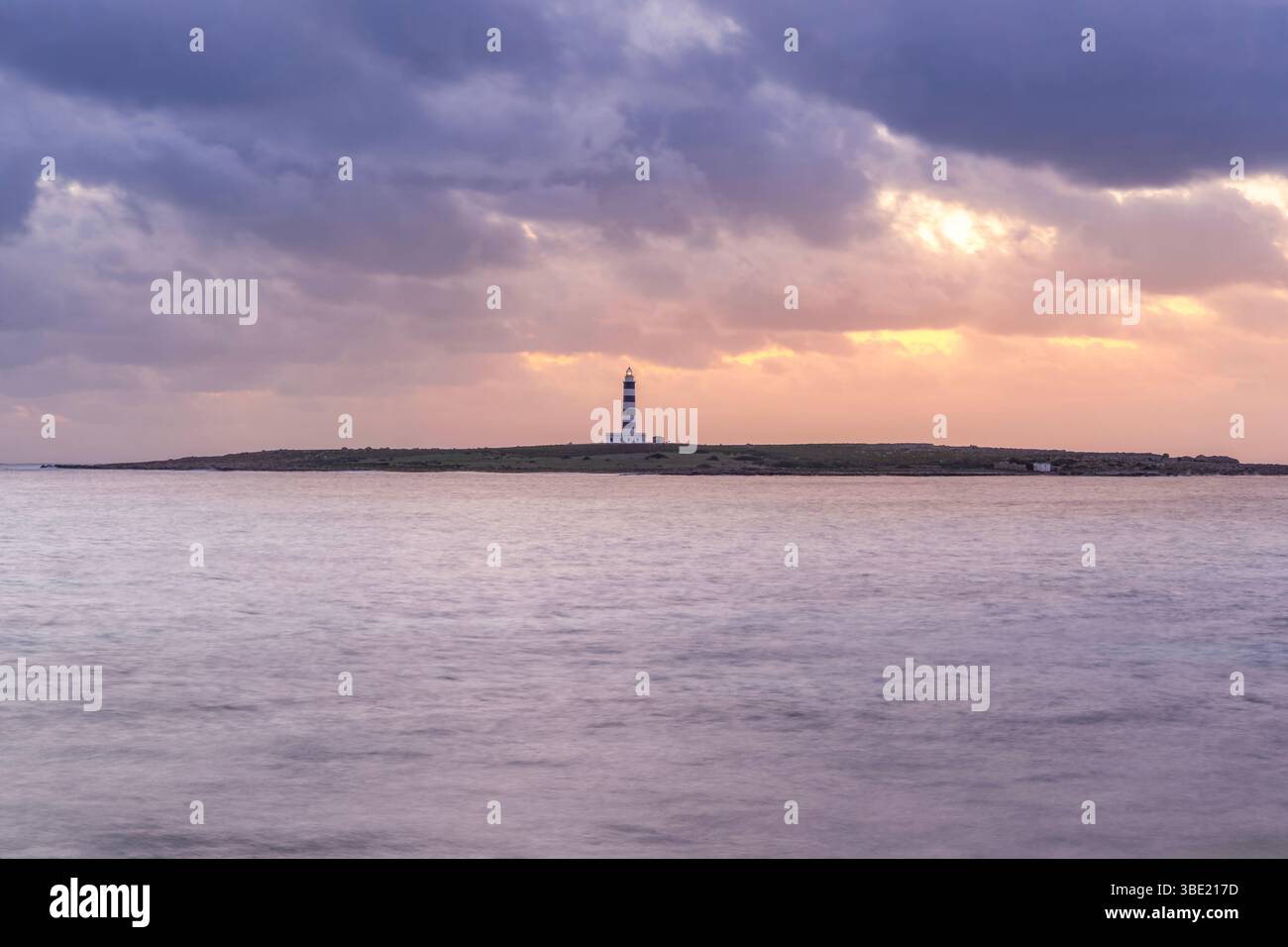 Faro dell'Illa del Aire su un isolotto di Minorca al tramonto. Isole Baleari, spettacolari nuvole, orizzonte oceanico, faro costiero, Travel destinati Foto Stock