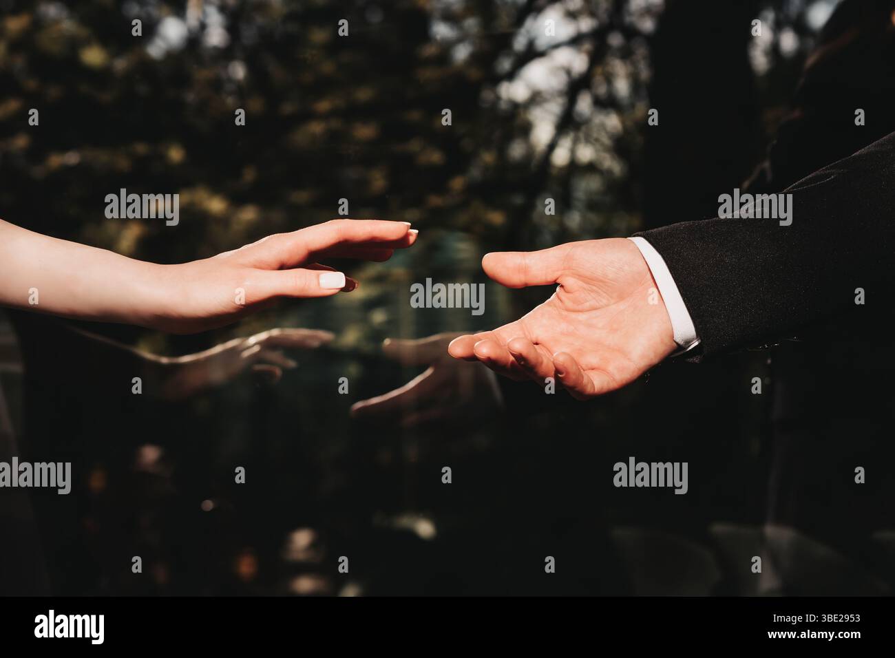 Mani, mano della donna che arriva alla mano dell'uomo. Immagine che esprime amore romantico, attaccamento e impegno. Foto Stock