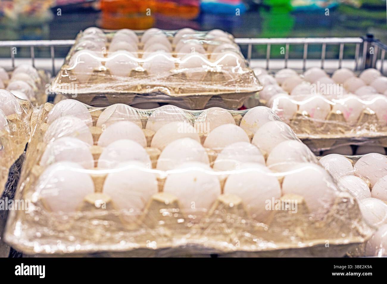 uova di pollo bianche in contenitori di cartone nel supermercato. Crisi mondiale Foto Stock