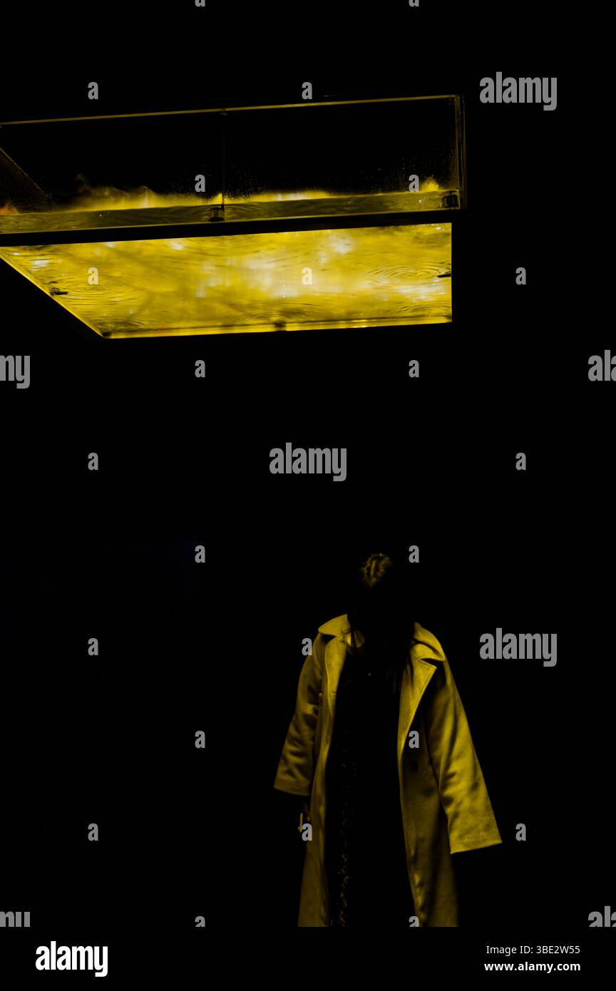 Il visitatore solitario si trova sotto un'installazione luminosa di colore giallo al Museum of Contemporary Art di Tokyo. Foto Stock