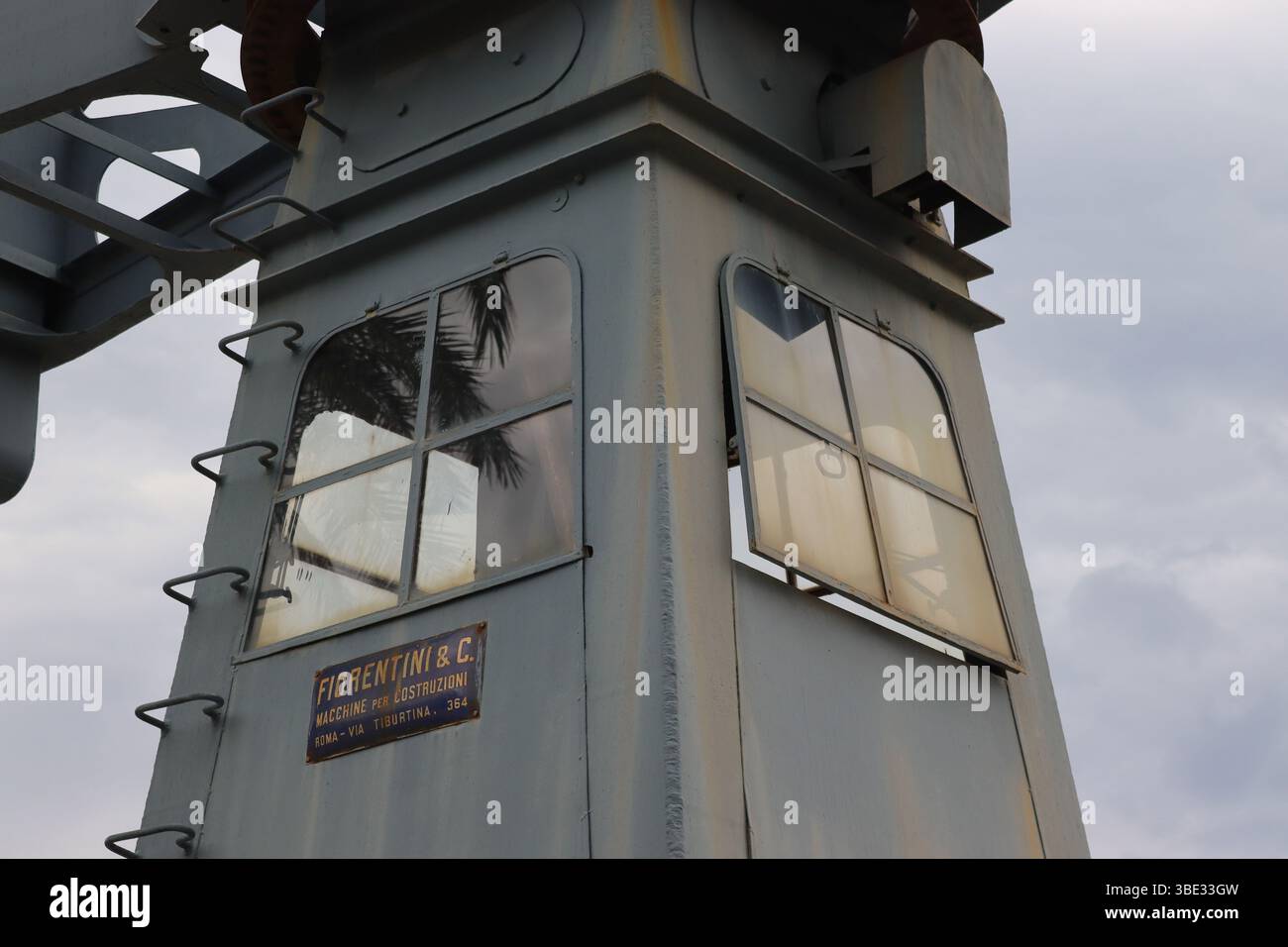 Primo piano che mostra dettagli esterni e patina della cabina operatore di una piccola gru portuale Fiorentini, conservata nel porto italiano di Geova. Foto Stock