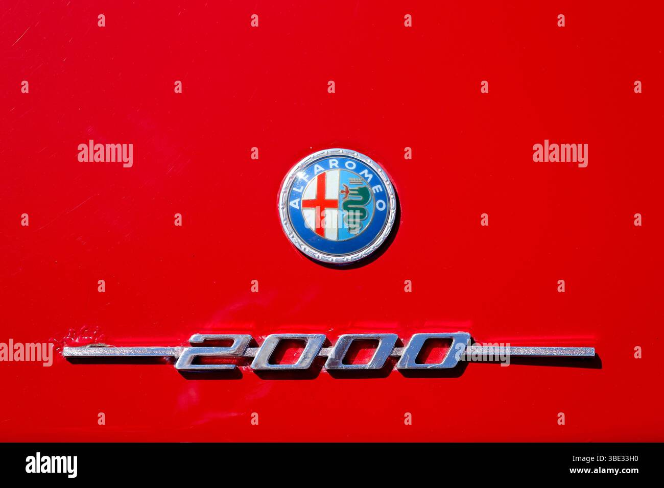 Un logo Alfa Romeo Giulia GT 2000 in lega cromata sullo sportello del bagagliaio risplende alla luce del sole in occasione di una mostra di auto d'epoca. Foto Stock