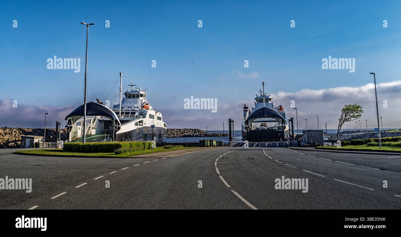 I traghetti attraccavano in un porto costiero con cieli limpidi e un'atmosfera tranquilla. La scena cattura la calma di un hub di viaggio avvolto nella morbida mattinata Foto Stock