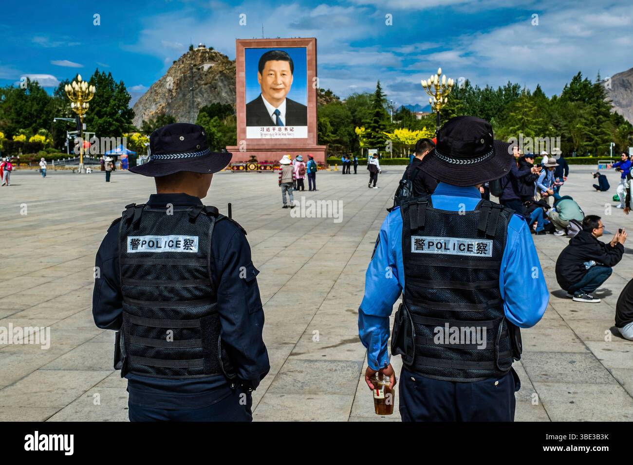 Cina, regione autonoma del Tibet, Lhasa, Piazza della Liberazione pacifica del Tibet o Palazzo del Potala, agenti di polizia di fronte a un ritratto gigante del leader Xi Jinping Foto Stock
