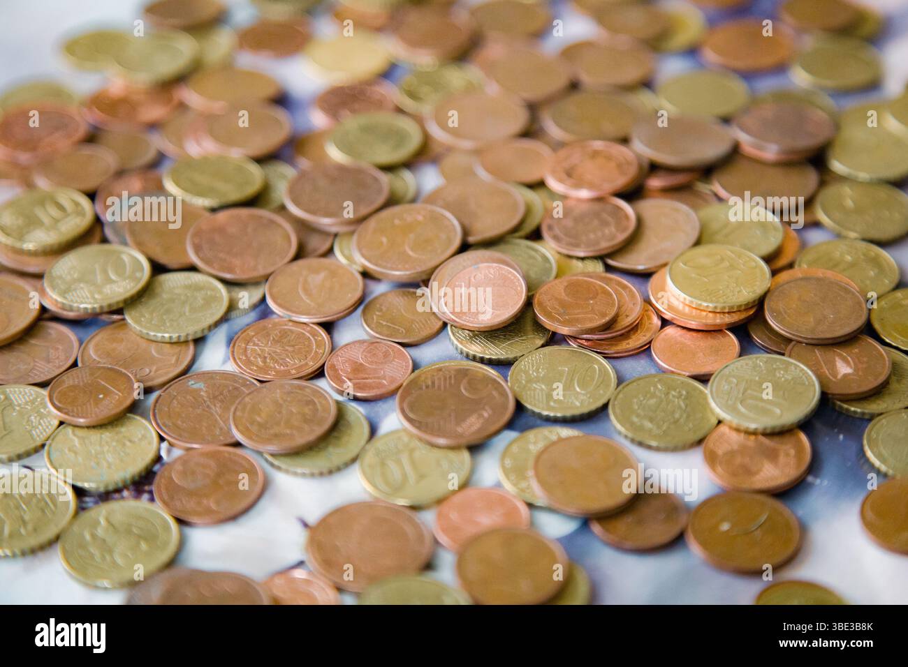 Monete sparse da un centesimo di euro in calde tonalità dorate-rosse - tagli da 1, 2, 5 e 10 centesimi - che formano uno sfondo ricco e strutturato Foto Stock
