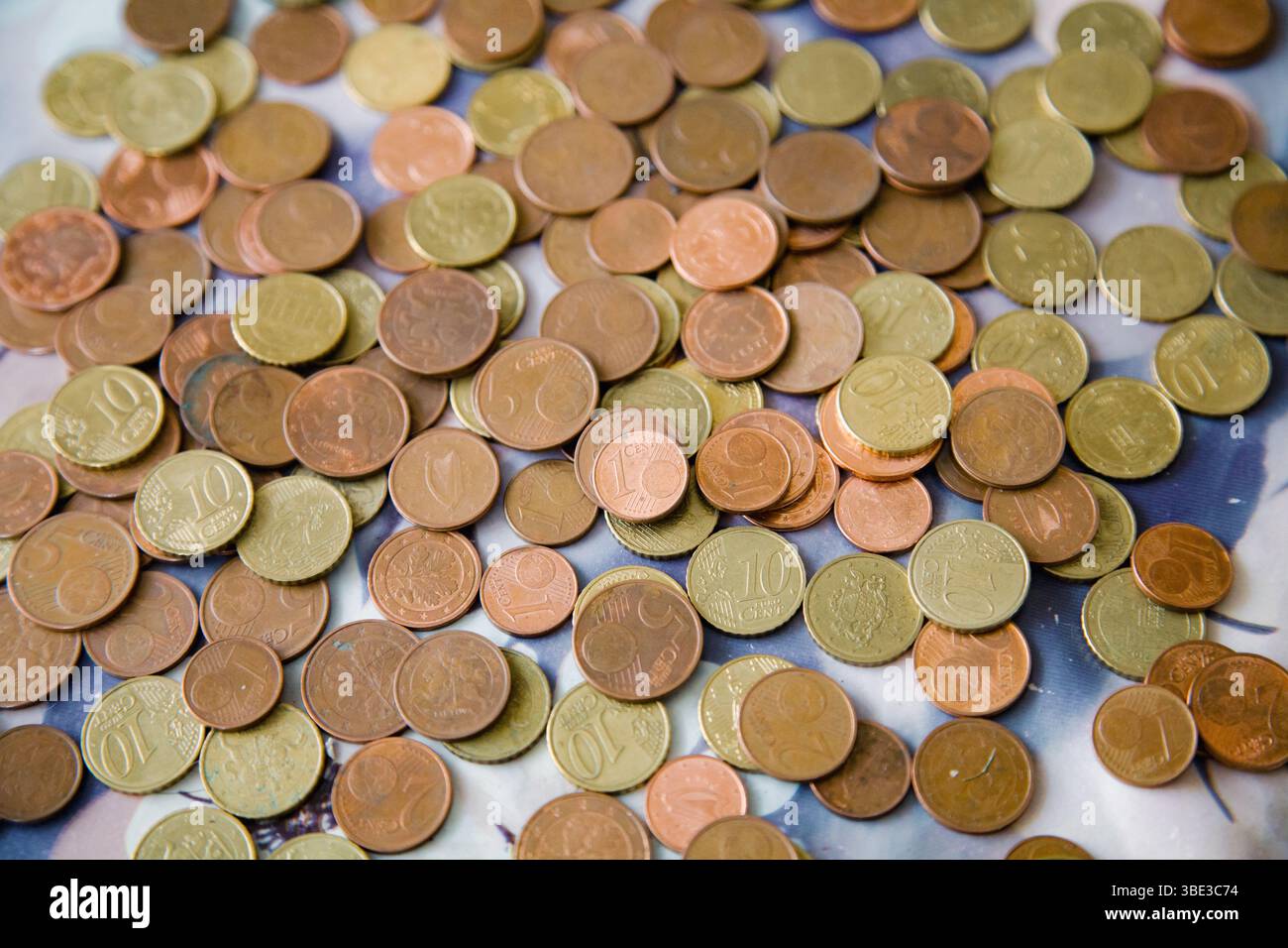 Monete sparse da un centesimo di euro in calde tonalità dorate-rosse - tagli da 1, 2, 5 e 10 centesimi - che formano uno sfondo ricco e strutturato Foto Stock