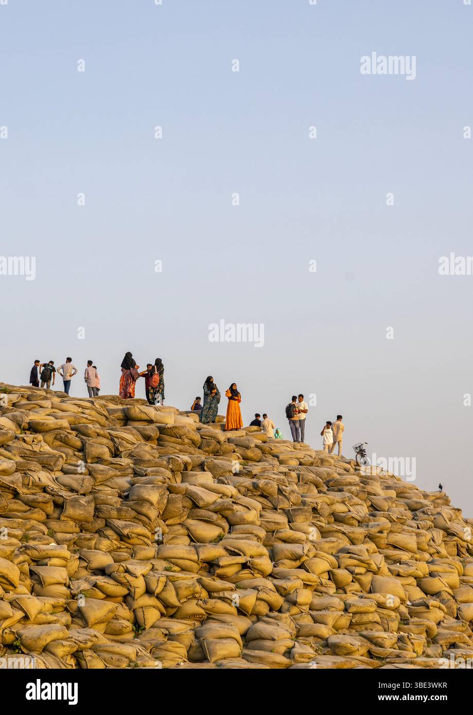 Persone che camminano su borse piene di sabbia per prevenire l'erosione, Rajshahi Division, Rajshahi, Bangladesh Foto Stock