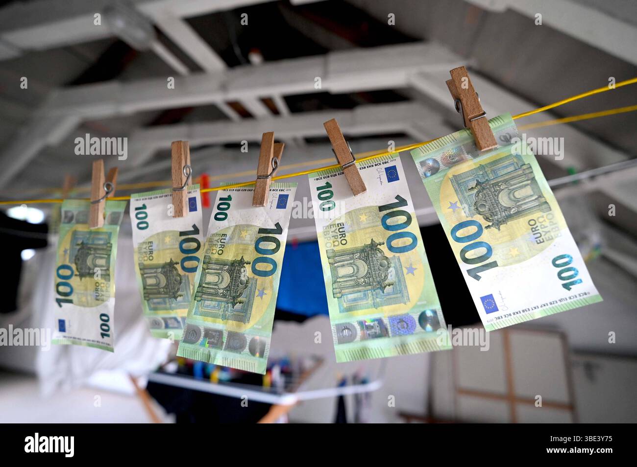 Themenfoto Geldwaesche, Geldscheine 100 Euro-Scheine haengen mit Waescheklammern auf einer Waescheleine, Feature, Symbolfoto, Randmotiv, Essen, 27.05.2025, *** servizio di lavanderia a tema, banconote da 100 euro appese con appendiabiti su una clothesline, elemento, foto simbolica, motivo di confine, Essen, 27 05 2025, Foto Stock