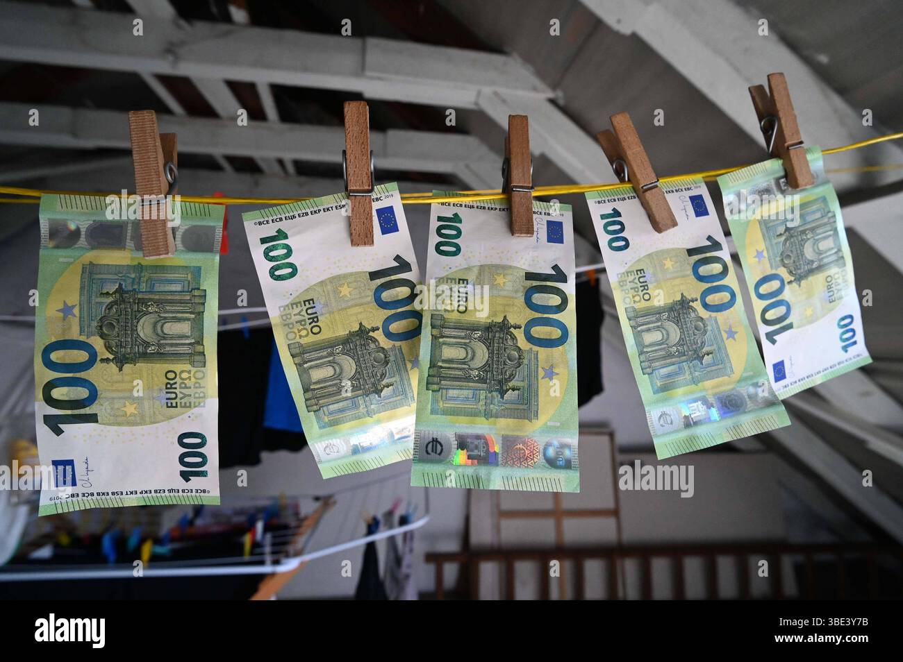 Themenfoto Geldwaesche, Geldscheine 100 Euro-Scheine haengen mit Waescheklammern auf einer Waescheleine, Feature, Symbolfoto, Randmotiv, Essen, 27.05.2025, *** servizio di lavanderia a tema, banconote da 100 euro appese con appendiabiti su una clothesline, elemento, foto simbolica, motivo di confine, Essen, 27 05 2025, Foto Stock