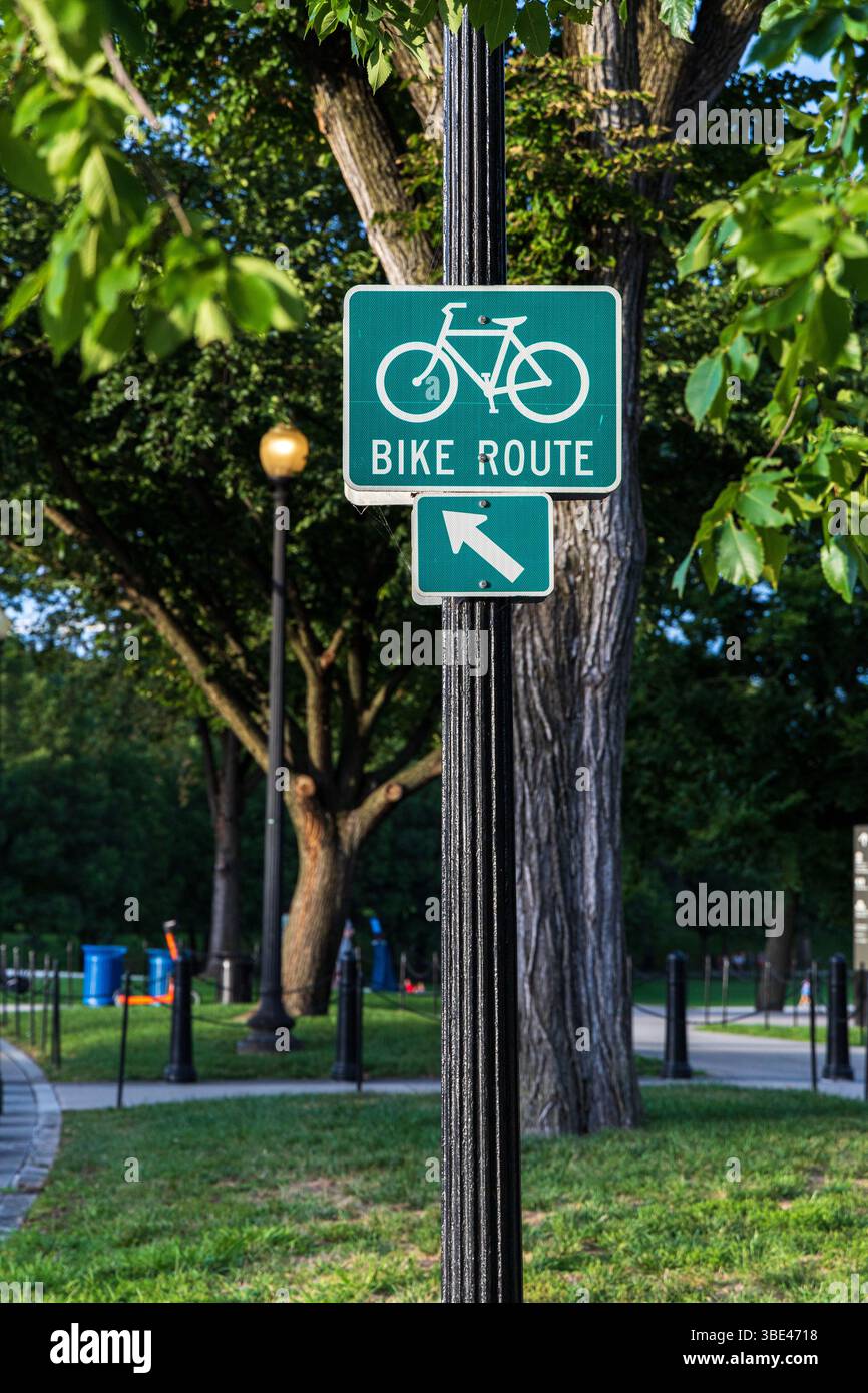 Un cartello verde con una freccia che punta verso destra. Il cartello è su un palo in un parco Foto Stock Un cartello verde con una freccia che punta verso destra. Il cartello è su un palo in un parco Foto Stock
