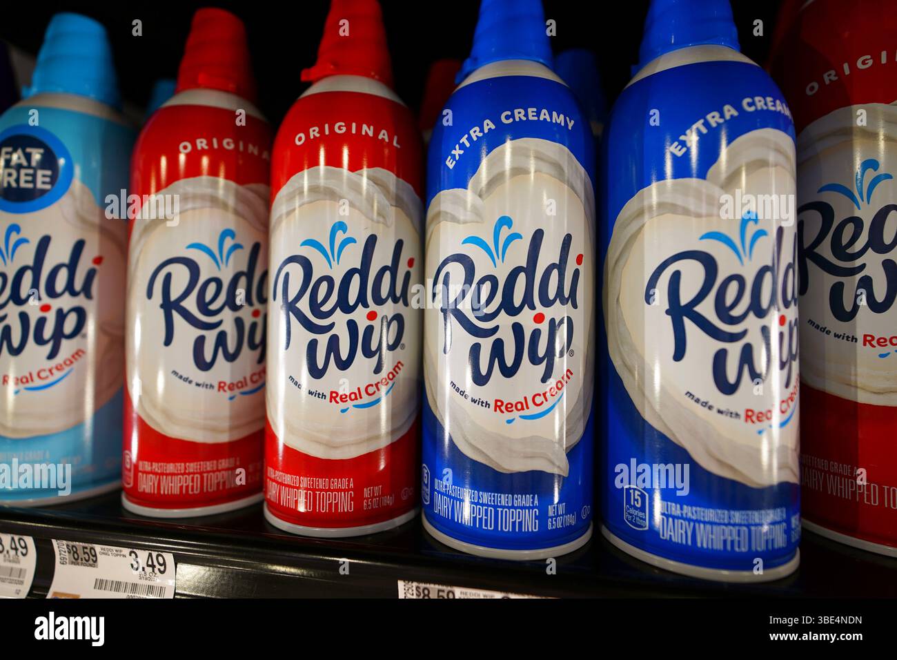 Lattine di canister Reddi con panna montata sul ripiano del negozio Foto Stock