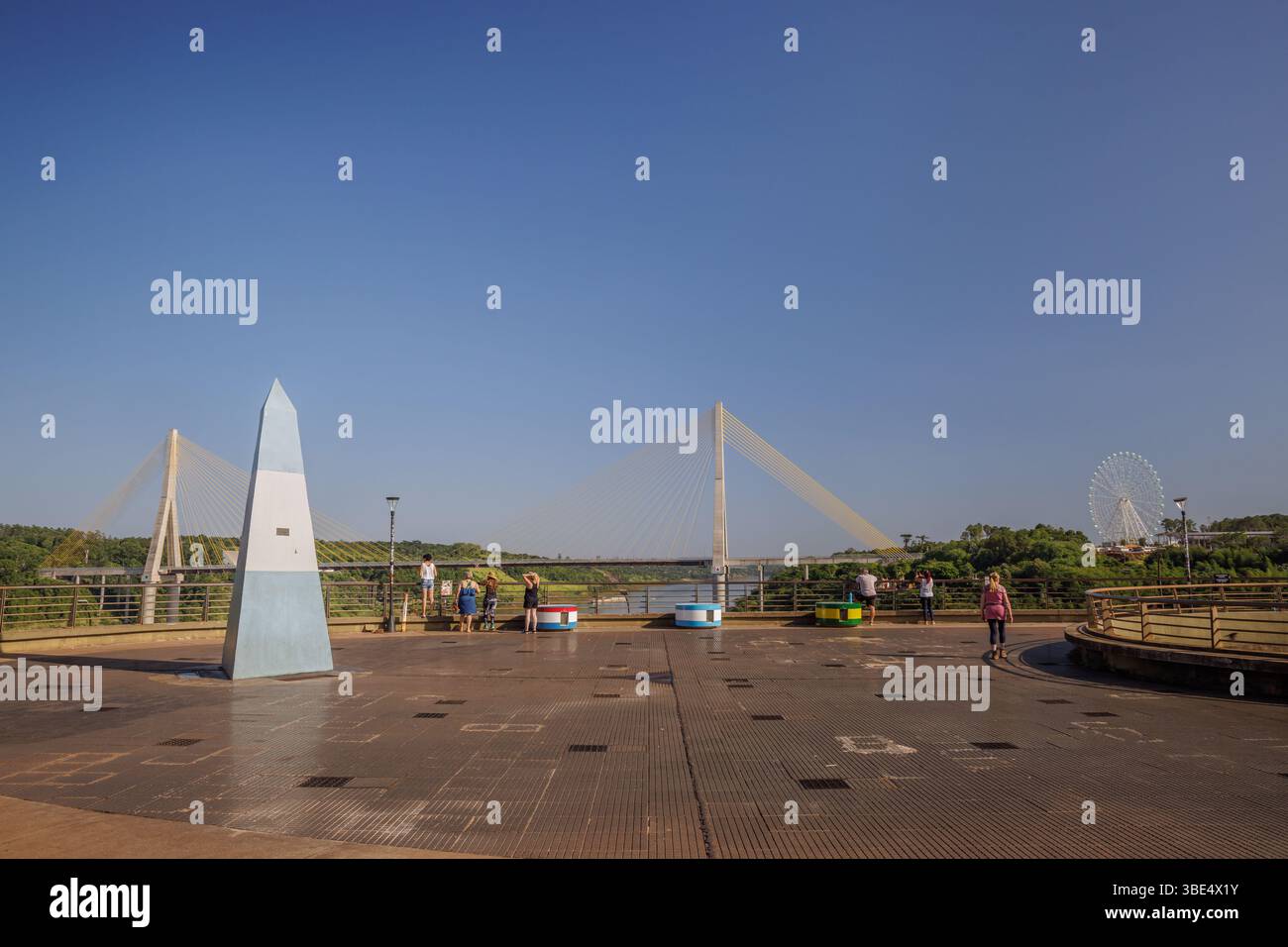 Puerto Iguazu, Misiones, Argentina - 18 maggio 2025: Turisti che camminano lungo il punto di riferimento dei tre confini. Foto Stock