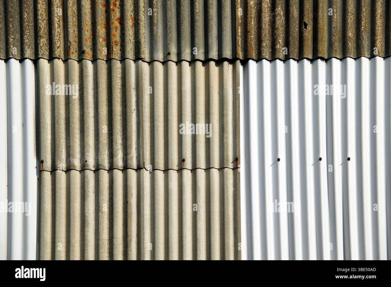 Sfondo con trama di recinzione in ferro ondulato arrugginito vecchio e rugginito, immagine fotografica del materiale da costruzione Foto Stock