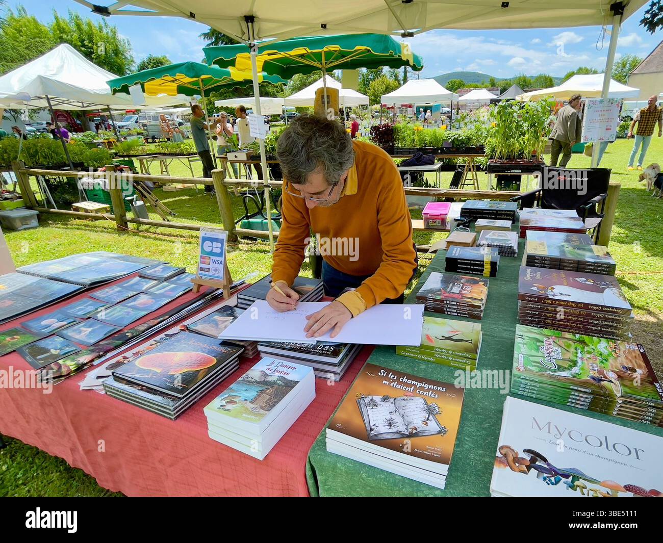Il celebre fotografo e autore, Benoît Peyre, firma uno dei suoi libri di funghi ad un evento all'aperto nella sua nativa Dordogna, in Francia Foto Stock
