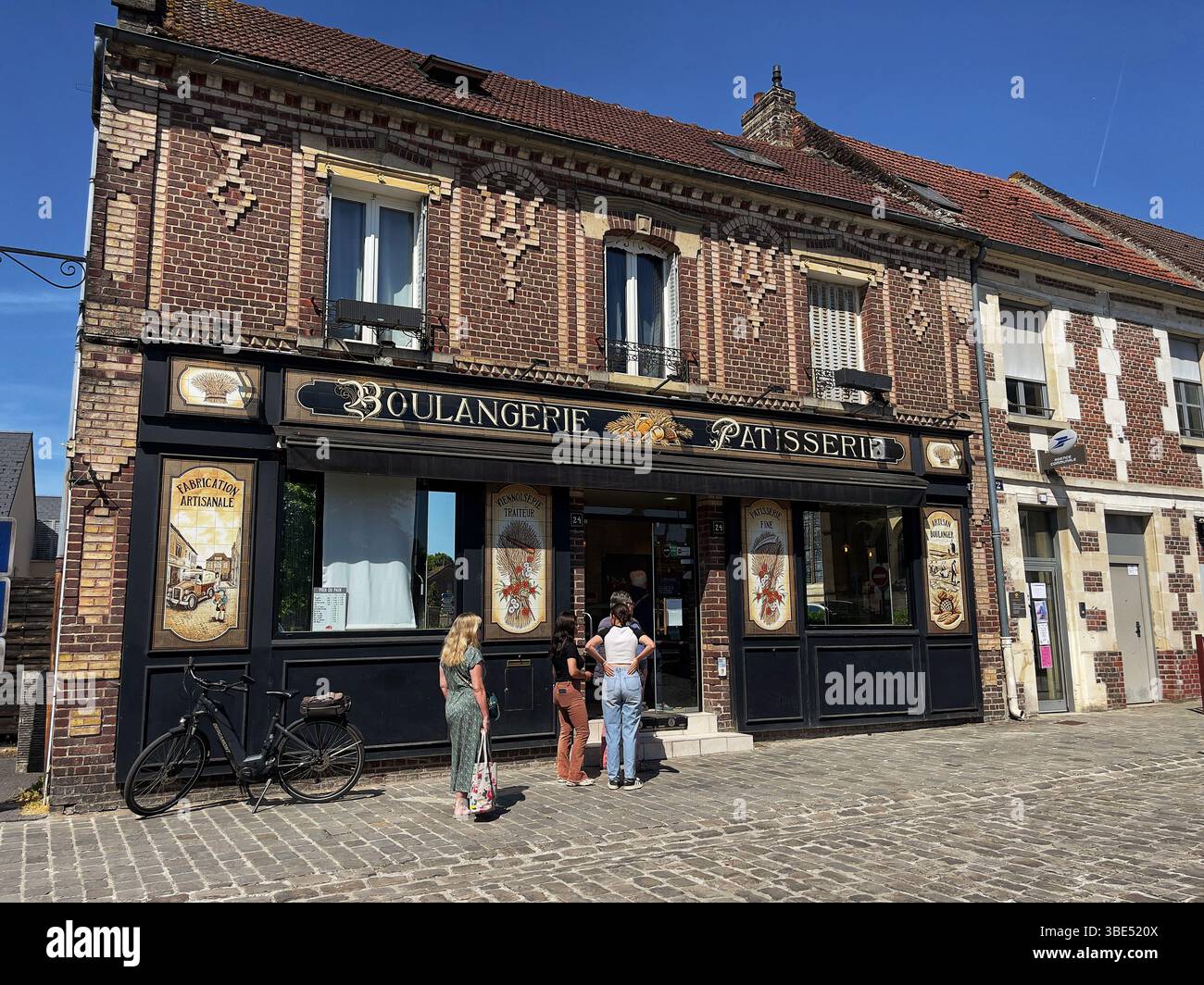 Di fronte a una premiata panetteria tradizionale francese a Chevrieres, in Francia, si forma una coda Foto Stock