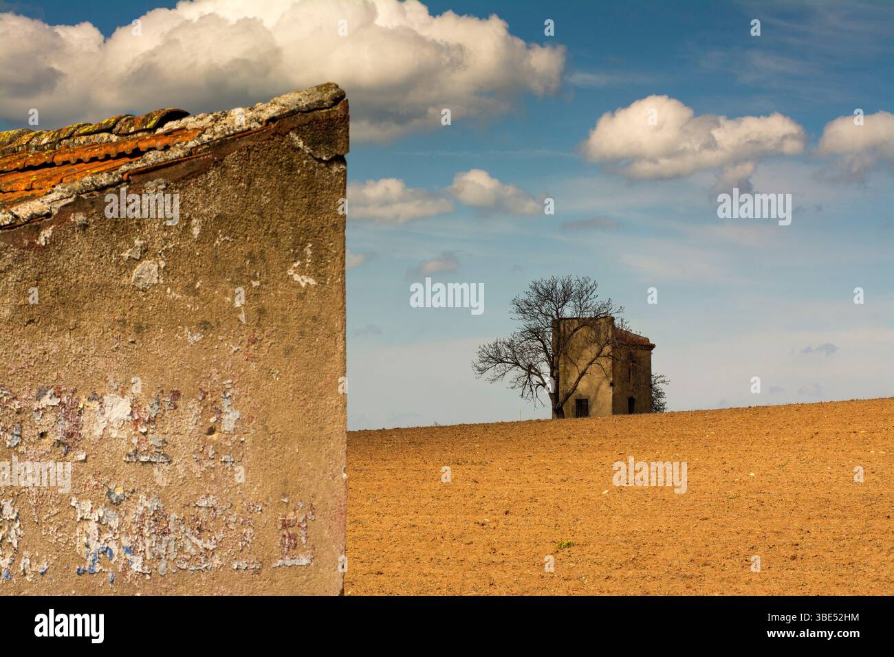 La colombaia rustica sorge elegantemente da un campo dorato, inondato dalla luce del sole. Morbide nuvole sparse attraverso il cielo blu, Puy de Dome, Auvergne , Francia Foto Stock
