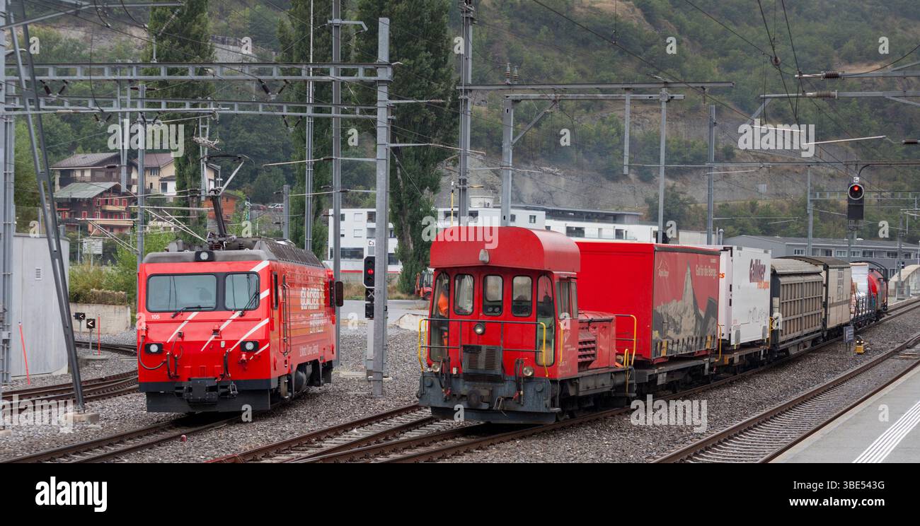 Matterhorn Gotthard Bahn GM 3/3 diesel shunter 71 arrivo a Visp con un carico per Zermatt dal deposito di trasferimento, posto elettrico in attesa a sinistra Foto Stock