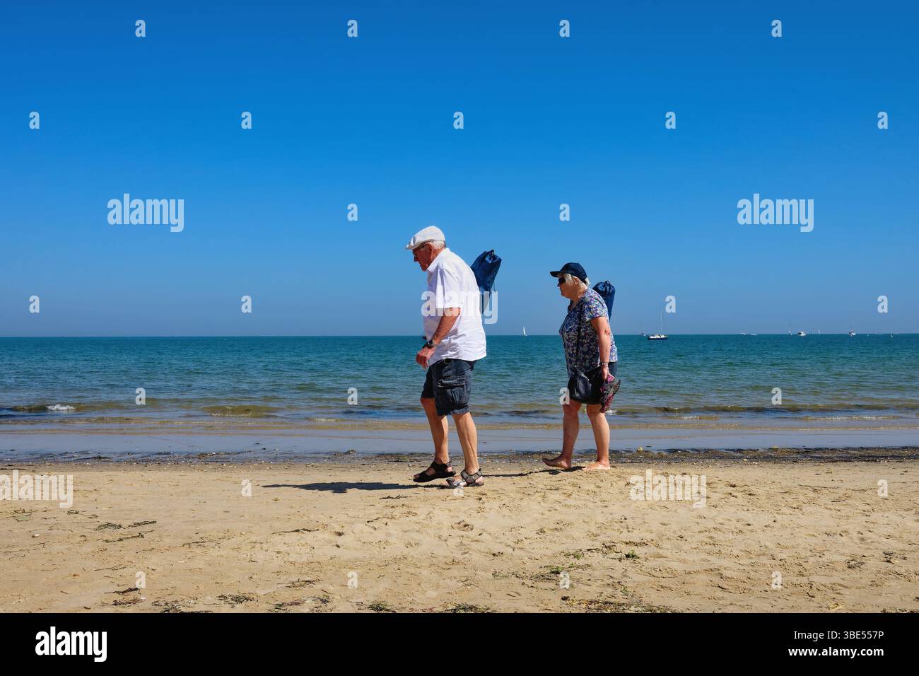 Una coppia di anziani fa trekking lungo la spiaggia di Studland in una calda giornata estiva nel Dorset Inghilterra Regno Unito Foto Stock