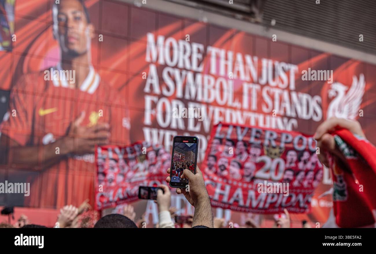 Guarda in aria tra la folla mentre guardi il video con uno smartphone fuori dallo stadio prima della partita di Premier League ad Anfield, Liverpool. Foto Stock