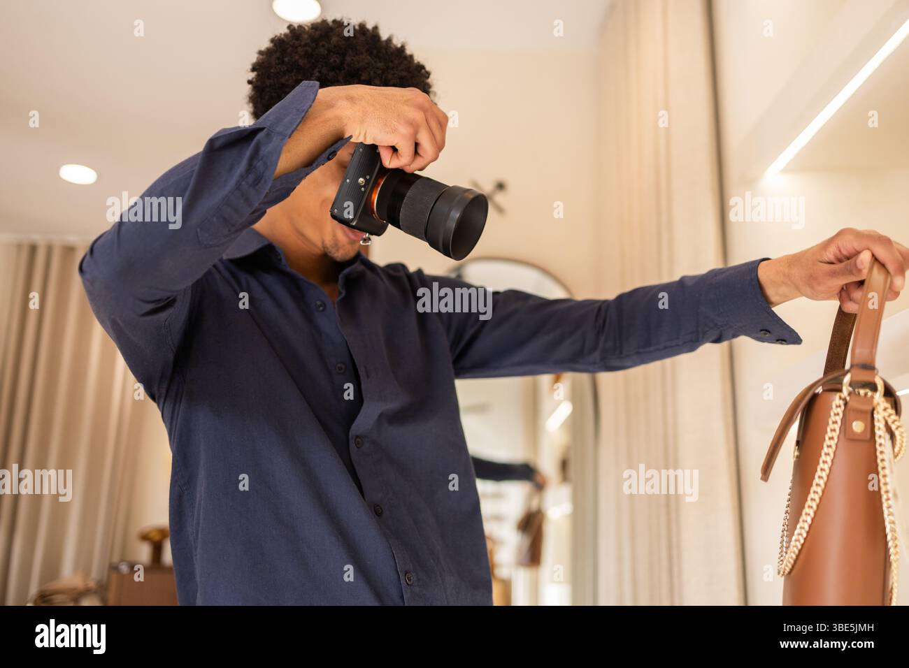 Un fotografo in un elegante negozio di borse cattura i dettagli di un'elegante borsa in pelle. Lo scatto mira a mettere in risalto il design e la cura artigianale del marchio Foto Stock