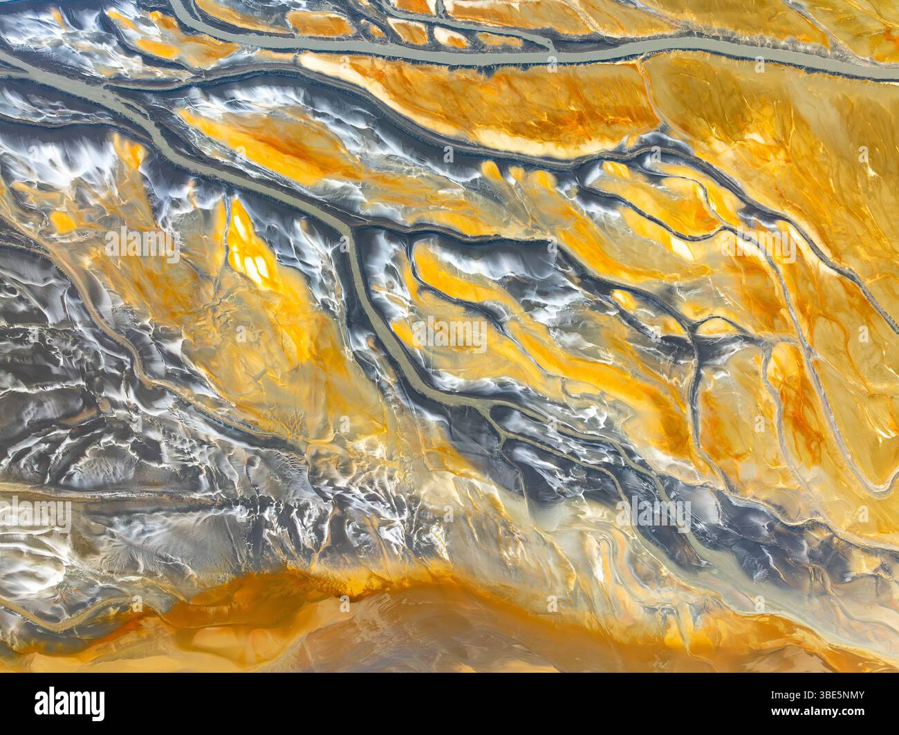 Dall'alto, un drone aereo cattura gli intricati motivi di texture astratte della natura, mostrando un'affascinante miscela di tonalità gialle e grigie che c Foto Stock