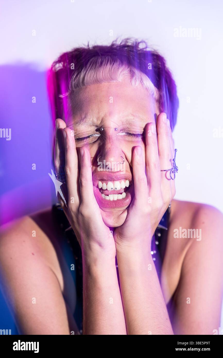 Un'immagine sorprendente di un modello di donna cyberpunk che esprime un'intensa emozione. La sua estetica futuristica è impreziosita da vivide luci al neon e da acce all'avanguardia Foto Stock