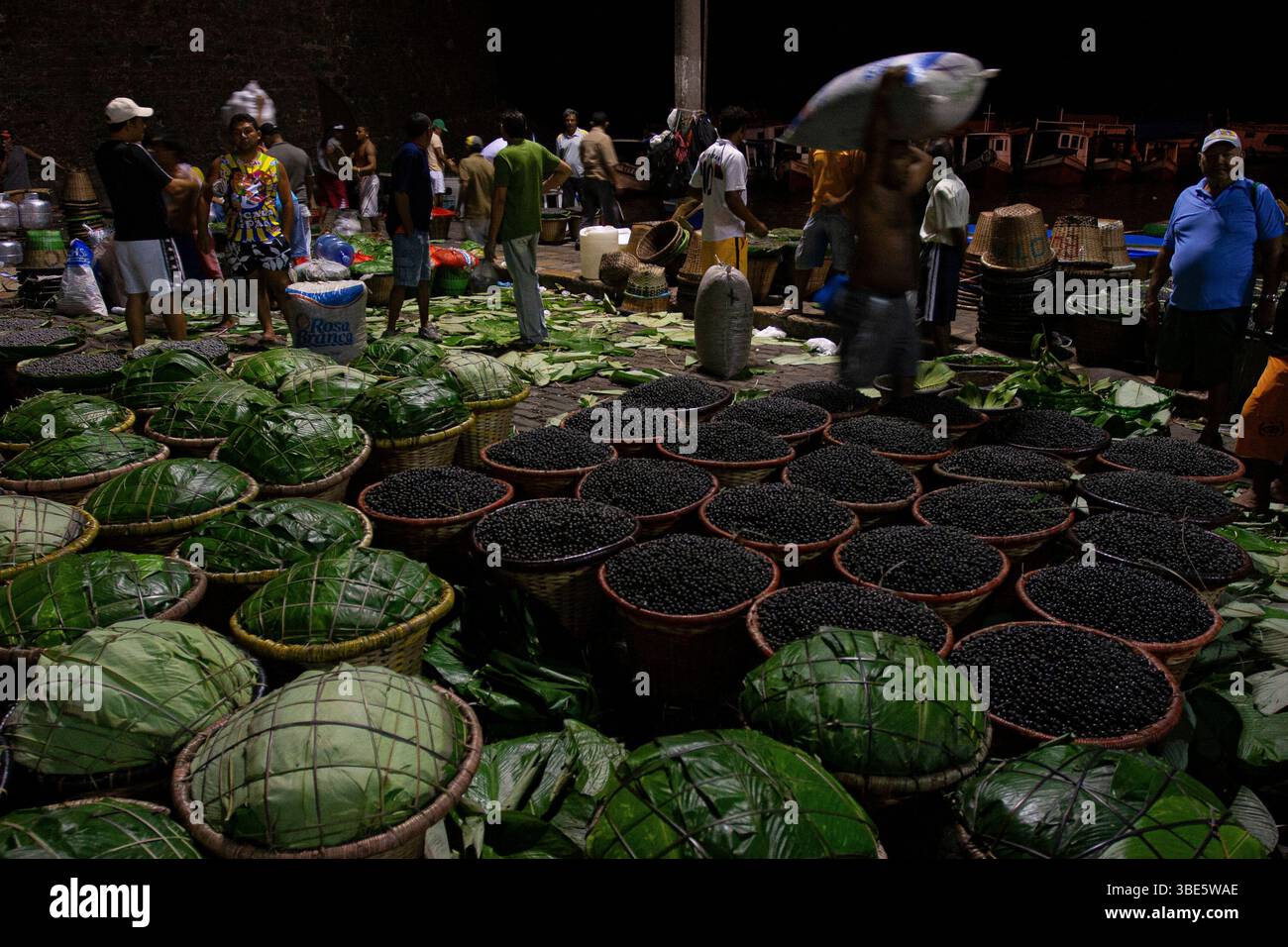 I cestini traboccanti di bacche di açaí raccolte dalla foresta sono scaricati al porto di Belém, accanto al mercato di Ver-o-peso. Foto Stock