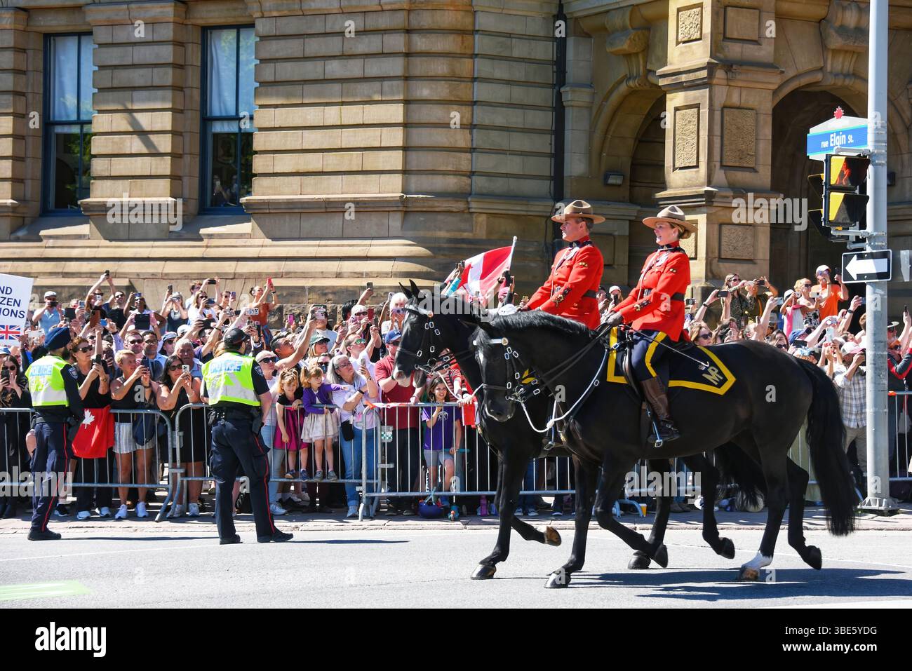 Ottawa, Canada - 27 maggio 2025: La Royal Canadian Mounted Police guida la strada per la carrozza che trasporta re Carlo III nella sua visita ad Ottawa. Il primo ministro Mark Carney ha invitato il re a tenere il discorso sul trono per celebrare la sessione di apertura del parlamento canadese. C'era un'enorme folla di persone che aspettavano di vedere il re. Foto Stock