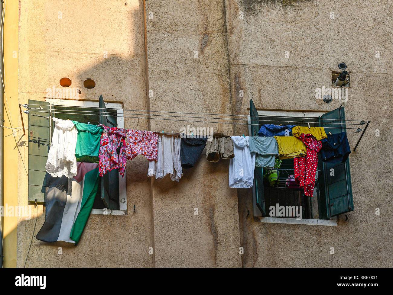 Linee di lavanderia con bandiera palestinese tra gli abiti appesi all'esterno delle finestre nel ghetto veneziano, Venezia, Veneto, Italia Foto Stock