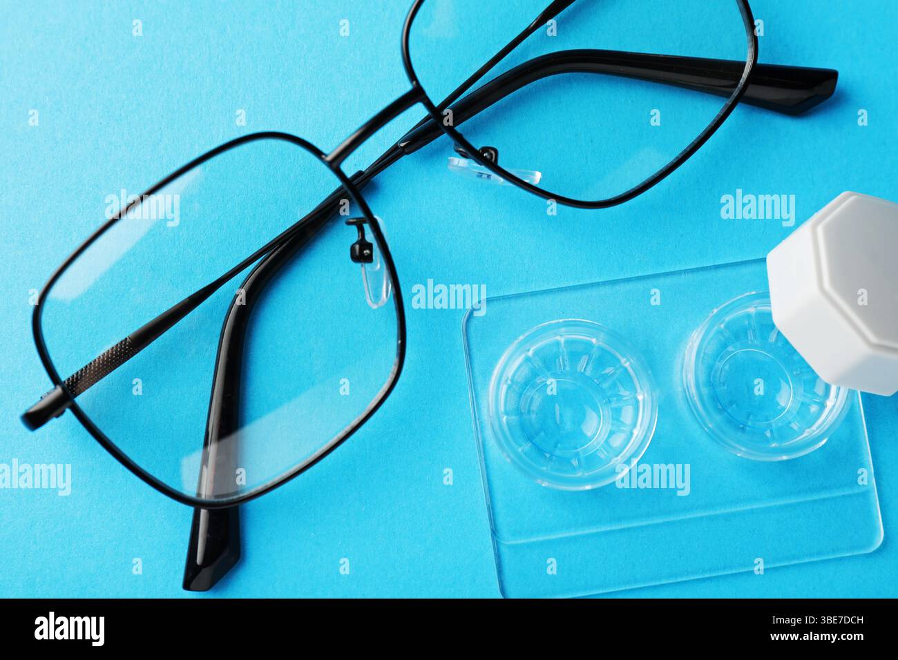 Lenti a contatto in astuccio e occhiali su sfondo azzurro, piatto Foto Stock