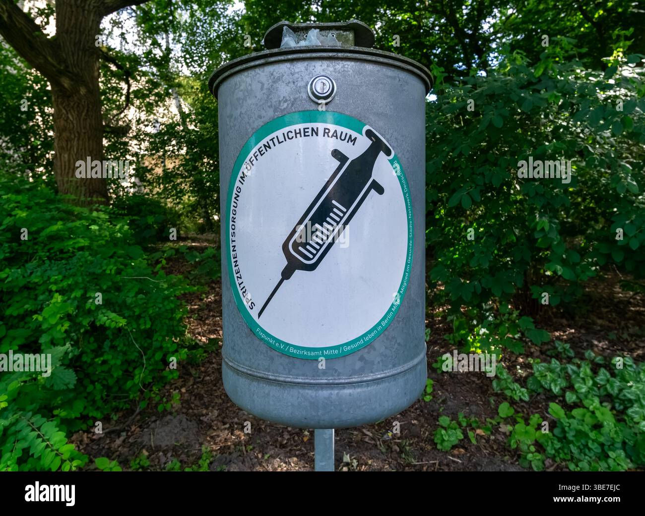 Contenitore per lo smaltimento delle siringhe nel parco Berlin-Tiergarten, parte di un programma di riduzione del danno vicino a un marciapiede pedonale. Foto Stock