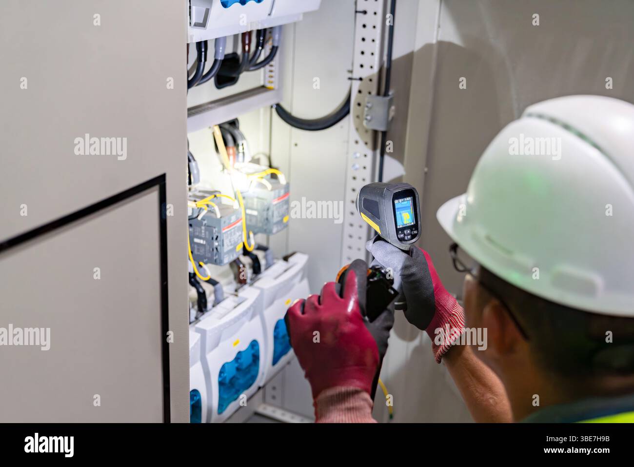 Temperatura di ispezione termometro a infrarossi del quadro di distribuzione principale per la manutenzione preventiva in fabbrica Foto Stock