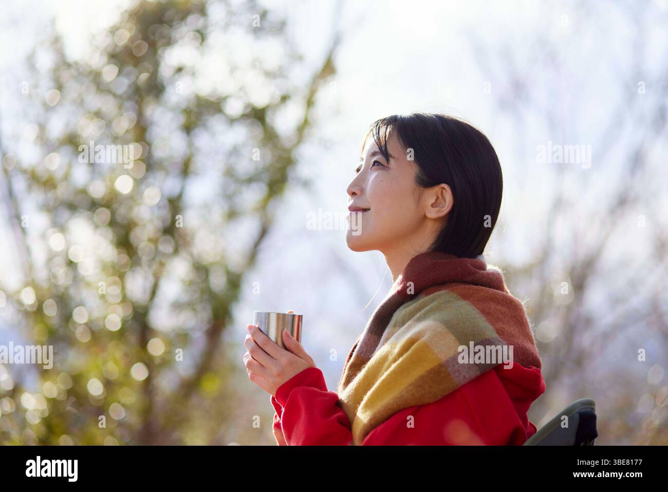 Donna giapponese che si diverte all'aperto con una tazza di caffè sulle montagne invernali. Foto Stock