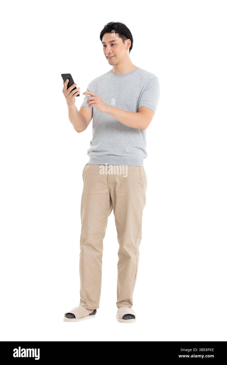 Un giovane che fissa il suo schermo del telefono, assolutamente entusiasta con il braccio alzato in alto Foto Stock