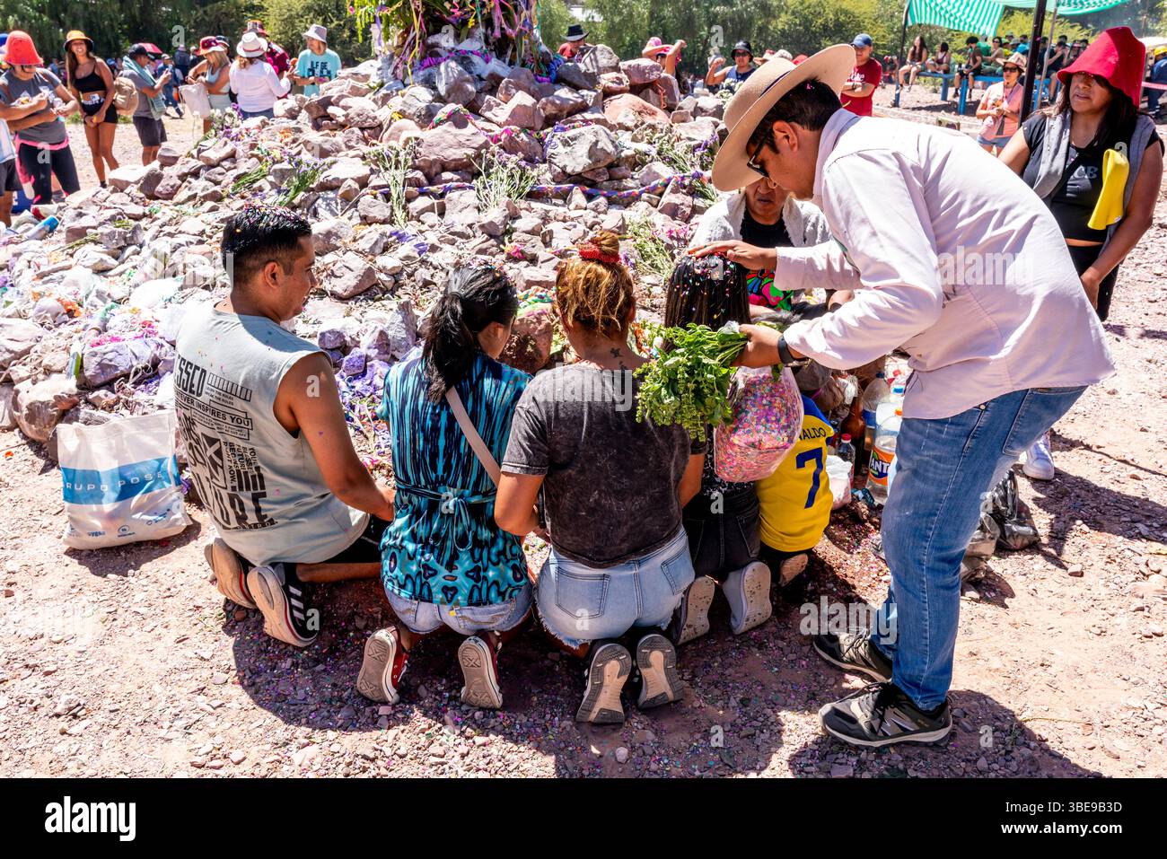 Gli argentini fanno offerte A Un Mojon (un gruppo di rocce che è un luogo sacro) durante il Carnevale annuale a Uquia, provincia di Jujuy, Argentina Foto Stock