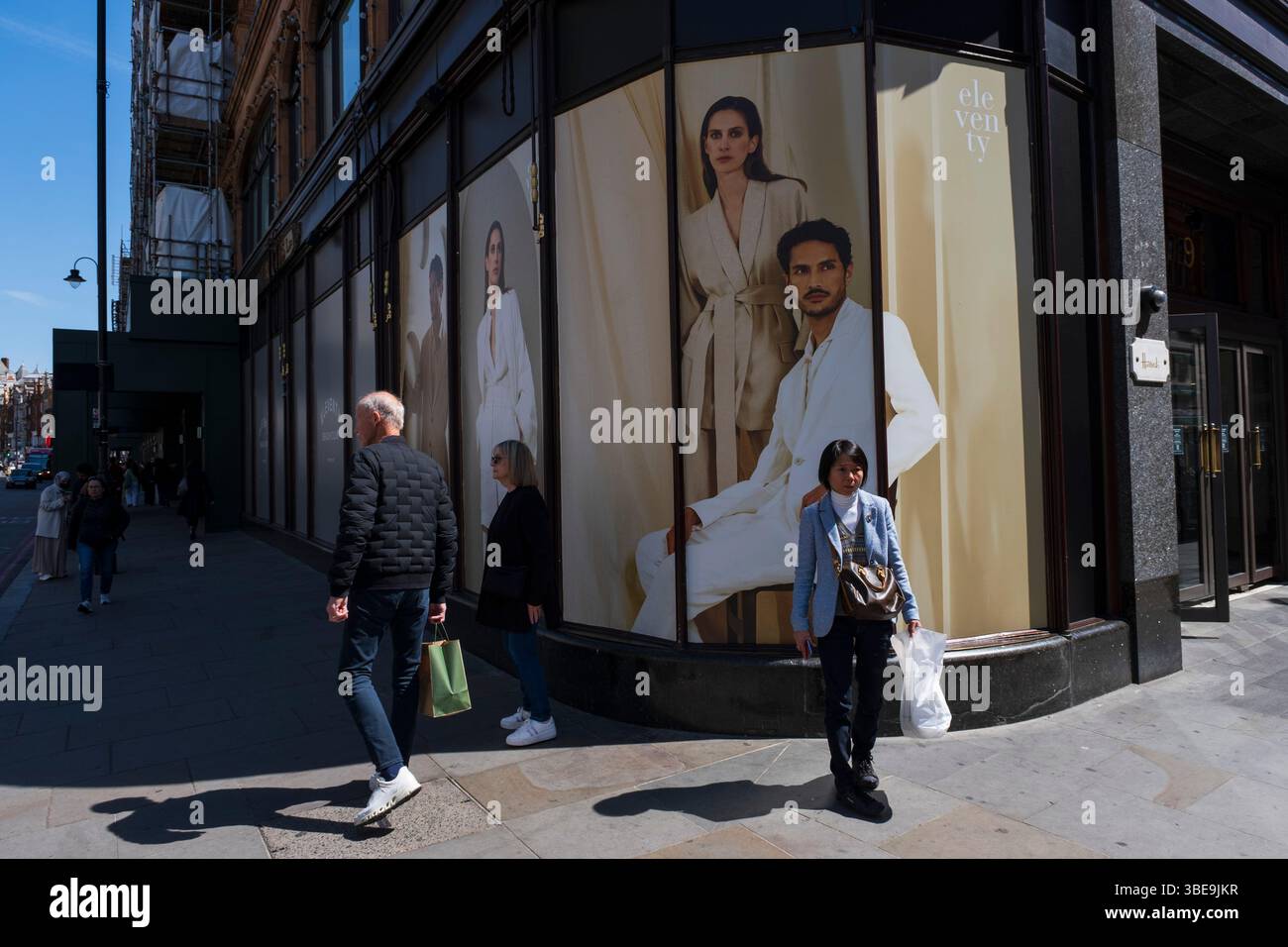 Persone fuori dai grandi magazzini Harrods nell'area esclusiva di Knightsbridge il 9 maggio 2025 a Londra, Regno Unito. Harrods Limited è un grande magazzino situato in Brompton Road, che è attualmente di proprietà dello stato del Qatar attraverso il suo fondo sovrano, la Qatar Investment Authority, ed è uno dei grandi magazzini più grandi e famosi al mondo. Foto Stock