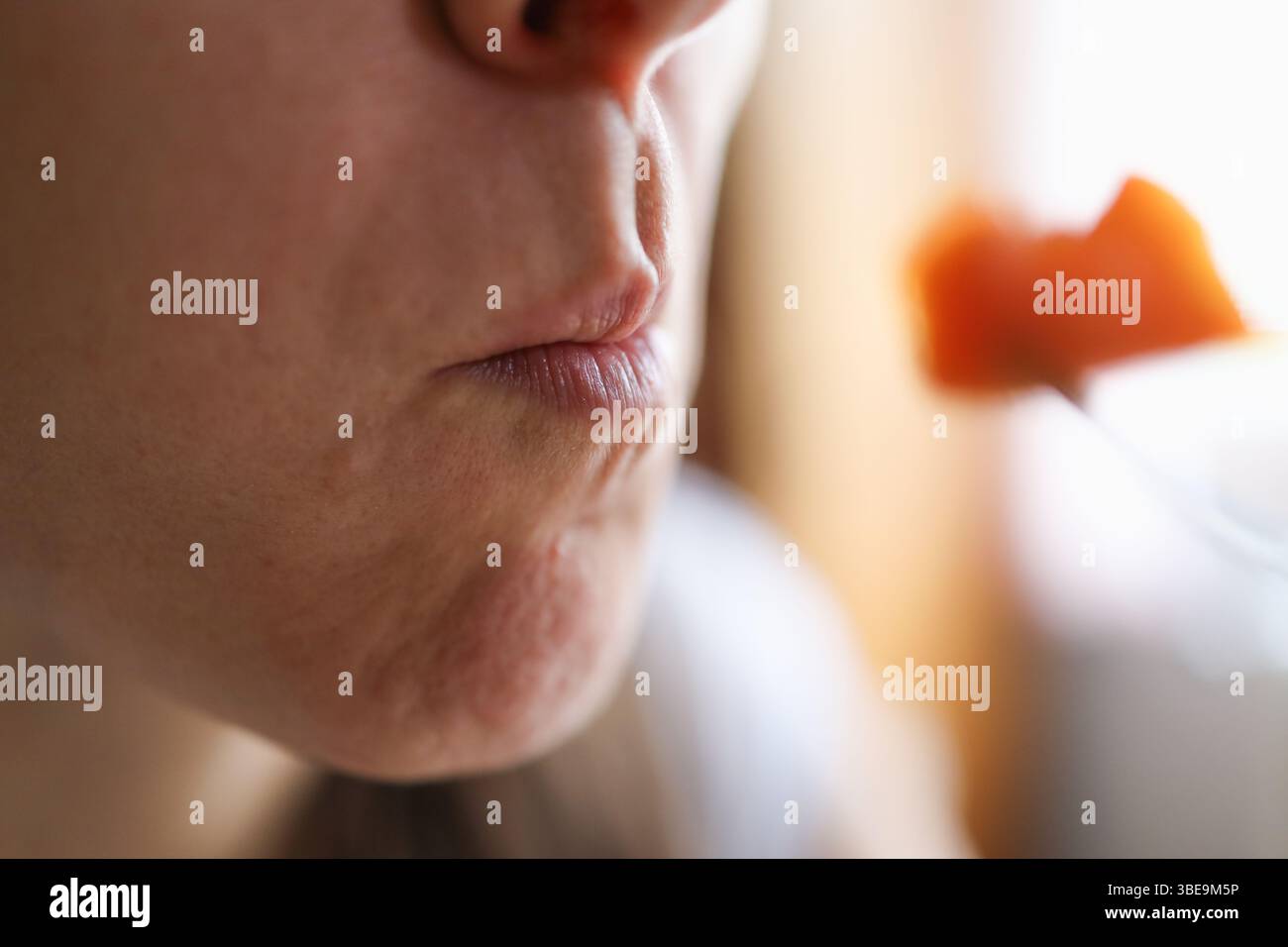 Vita alimentata dalle piante: Donna che mangia carota per un pasto radioso e nutriente. Foto Stock