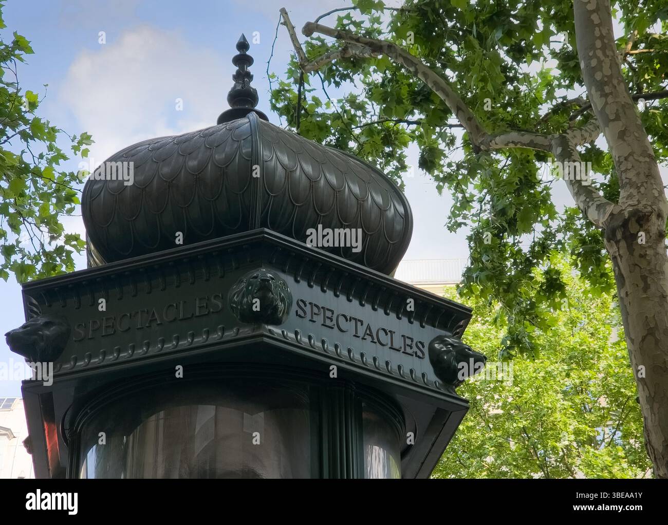 Colonna parigina Morris con spettacoli pubblicitari sotto un albero di sicomoro Foto Stock