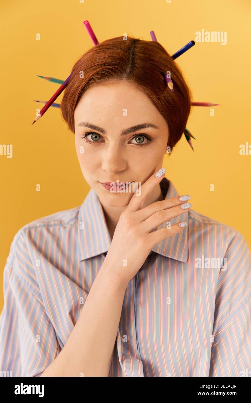 Una giovane donna posa con le matite nei capelli, mostrando stile e stile creativi. Foto Stock
