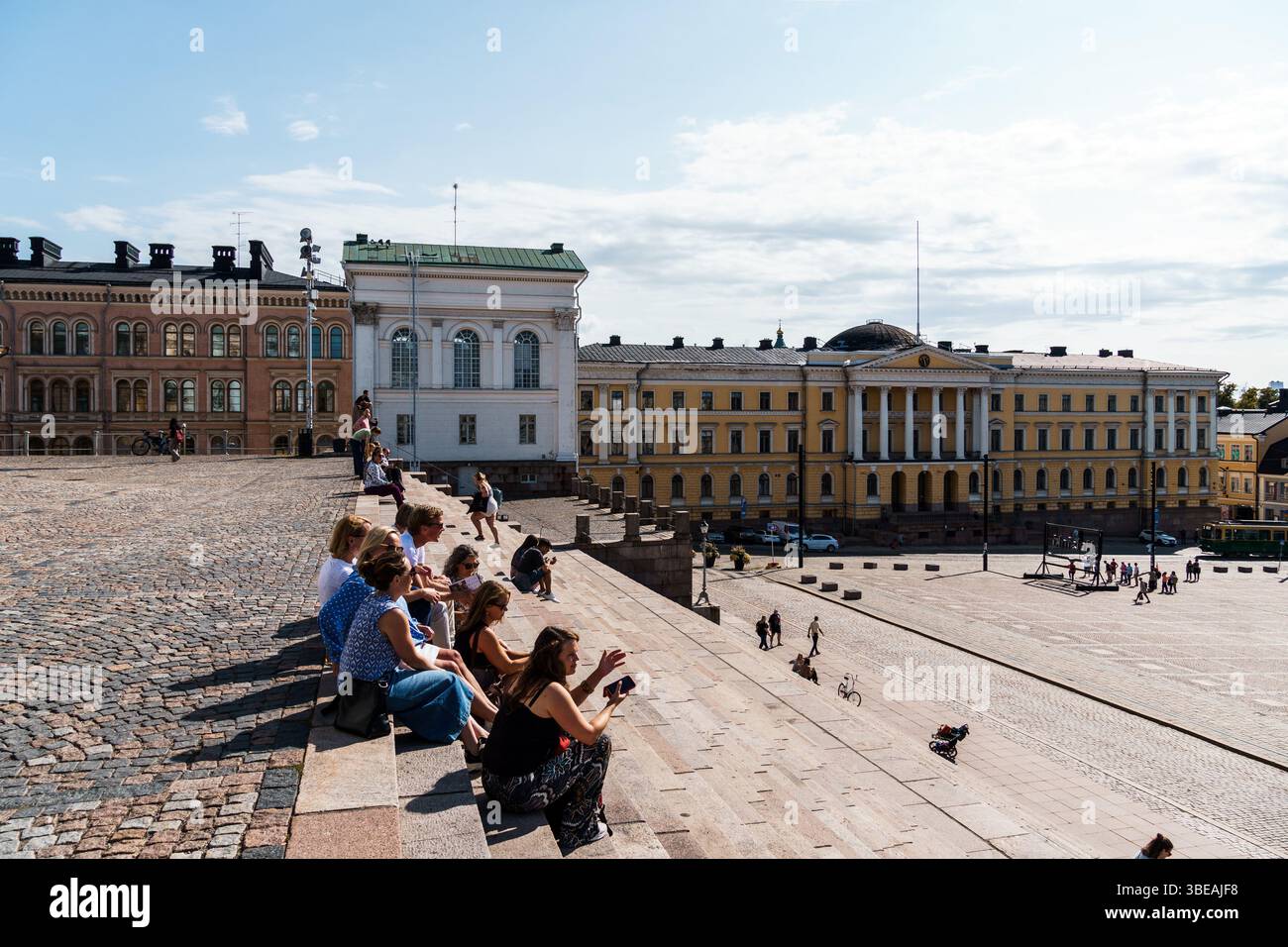 Helsinki, Finlandia - 19 agosto 2024: Le persone godono di una giornata di sole nella Piazza del Senato di Helsinki, in Finlandia, con i suoi edifici storici che creano un pittoresco qu Foto Stock