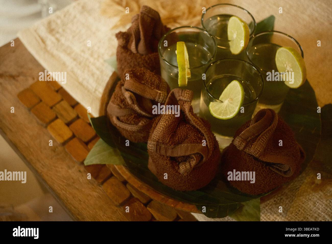 Vassoio di benvenuto rinfrescante con quattro bicchieri di acqua tiepida e asciugamani caldi piegati Foto Stock