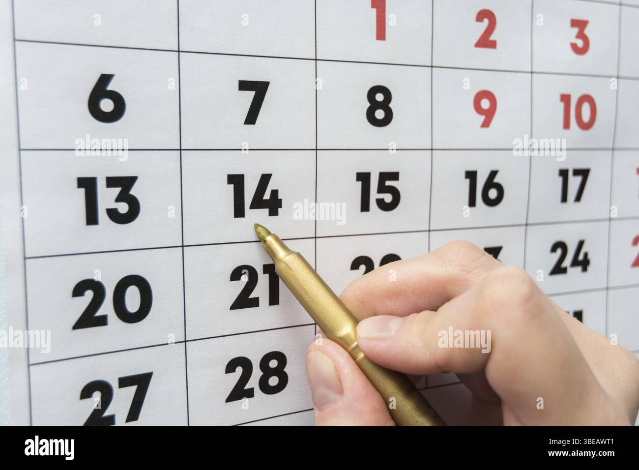 Marcatore a mano indica la data sul calendario da parete Foto Stock