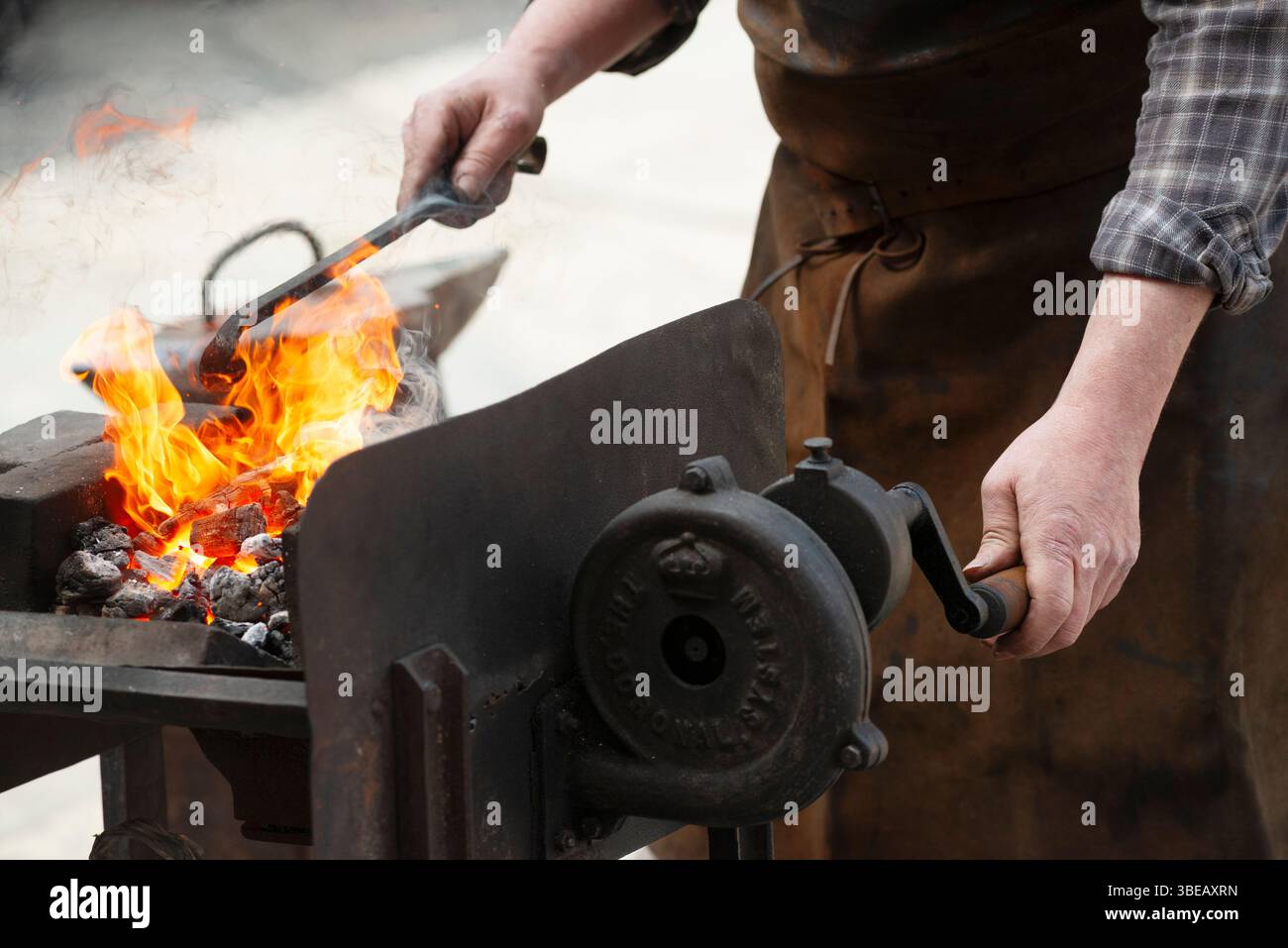 Metallo riscaldante del fabbro in un forno aperto Foto Stock